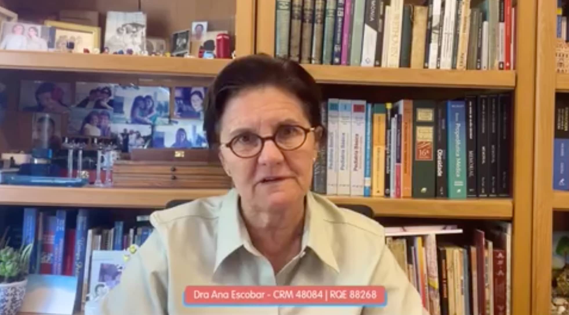 Livros de educação e biografia de Dr. Ana Escobar, especialista em saúde infantil, em seu escritório de estudos com fundo de estantes repletas de livros, promovendo o ensino de qualidade no Diário Escola.