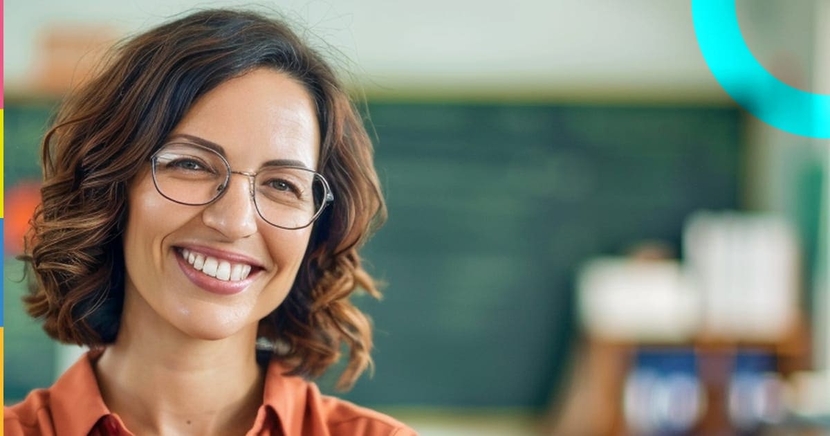 Imagem de uma professora sorridente em sala de aula, transmitindo entusiasmo e dedicação ao ensino presencial.